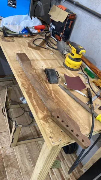Bancada de luthier com braço de guitarra em processo de lixamento
