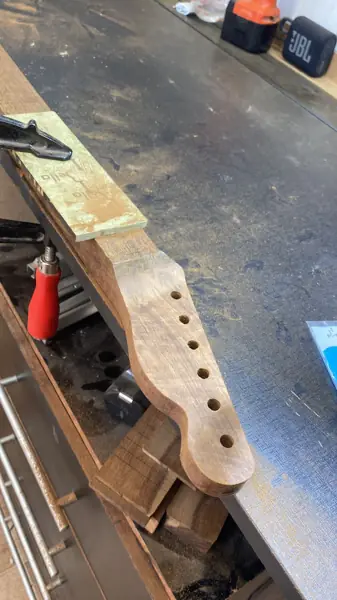 Braço de guitarra fixado na morsa durante ajuste de acabamento