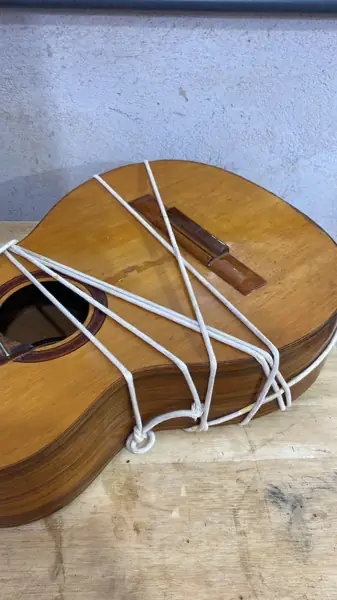Violão amarrado para colagem durante reparo estrutural