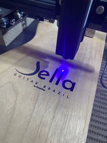 Máquina de gravação a laser marcando a logo Bella Guitar Brazil