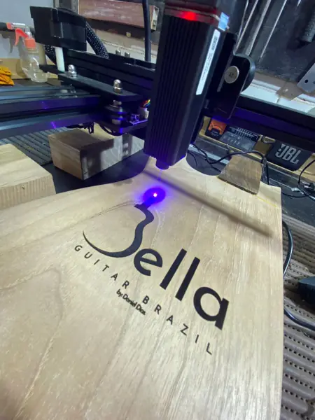 Gravação a laser da logo Bella Guitar Brazil em madeira