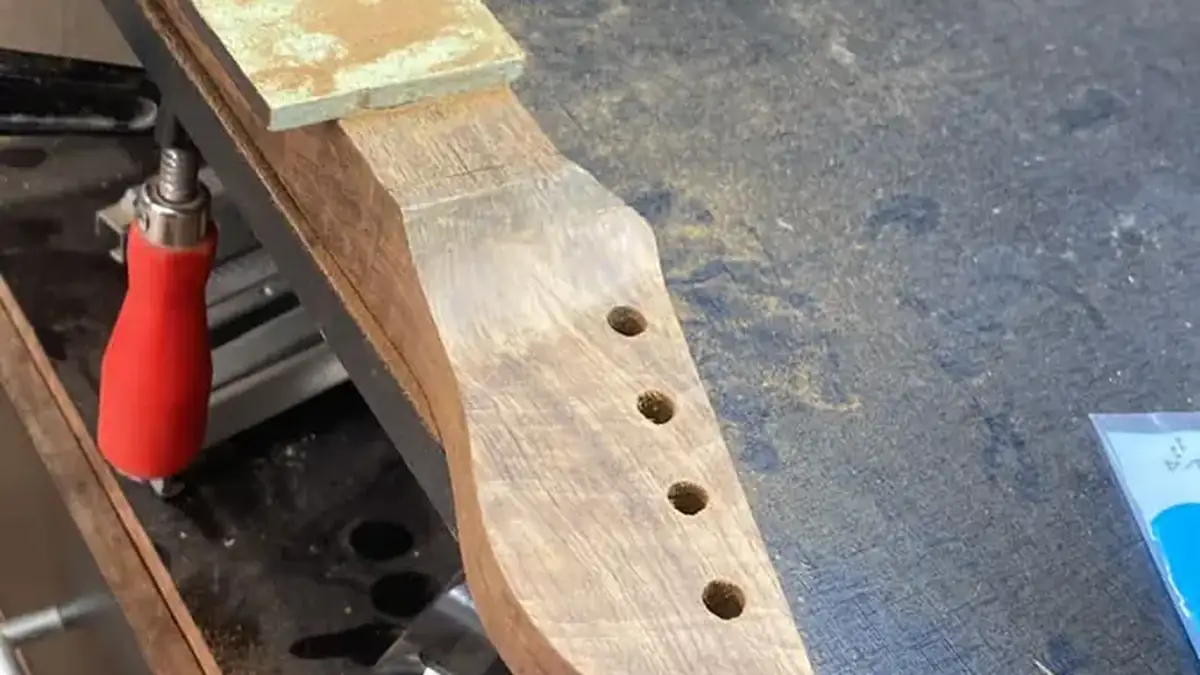 Braço de guitarra fixado na morsa durante ajuste de acabamento