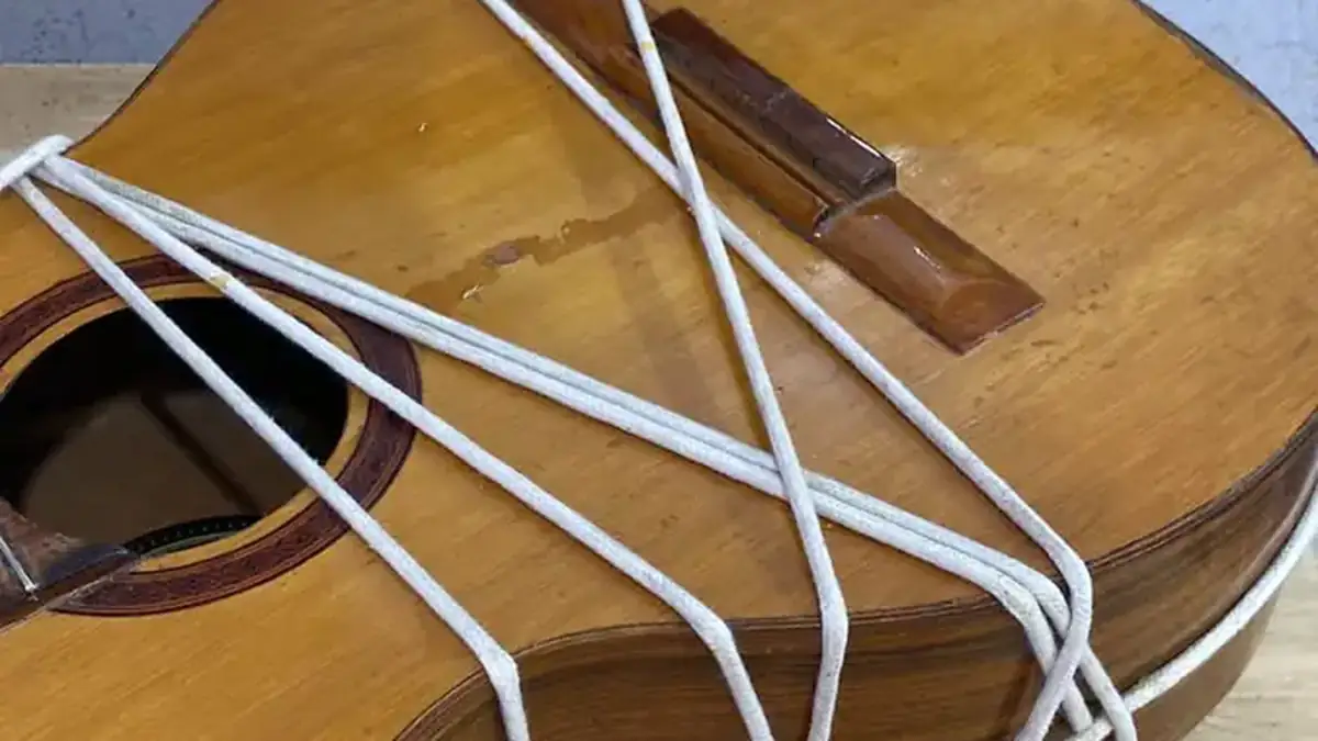 Violão amarrado para colagem durante reparo estrutural