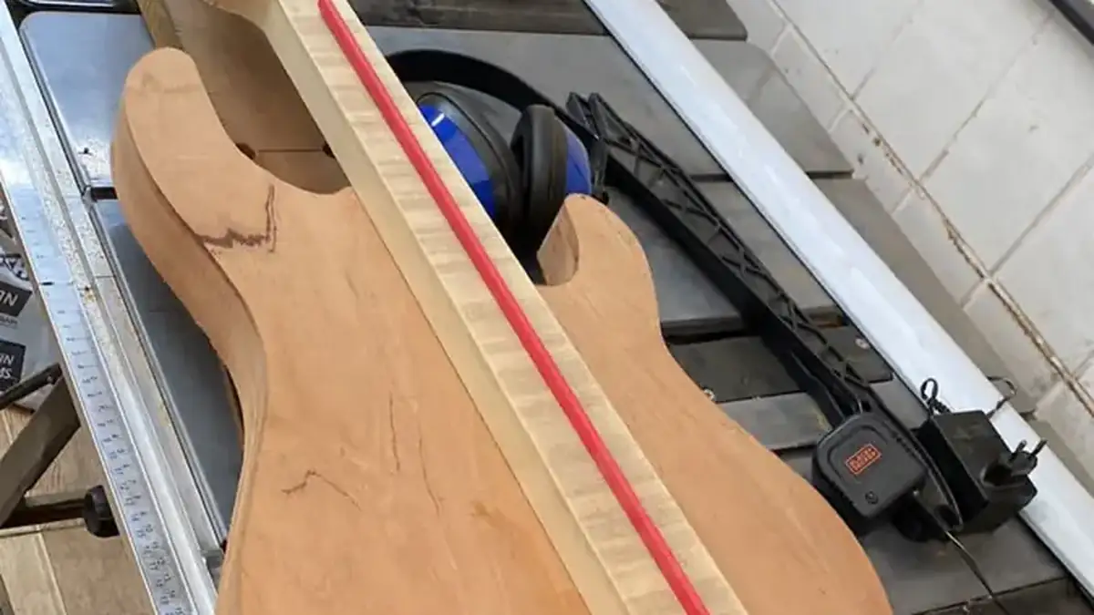 Corpo de guitarra em madeira avermelhada com marcação para encaixe do braço