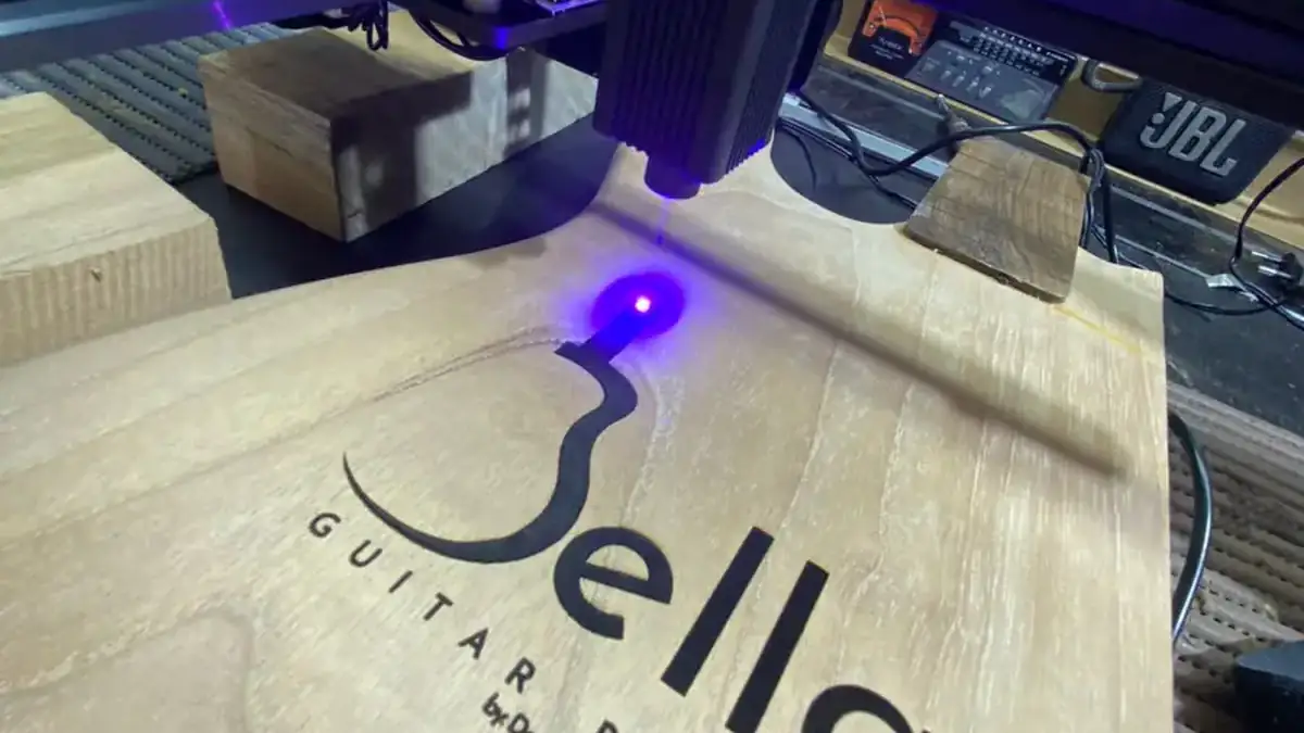 Gravação a laser da logo Bella Guitar Brazil em madeira